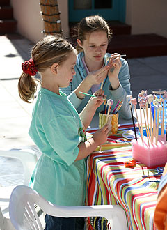 Girls painting beads at the Ben's Bells studio.