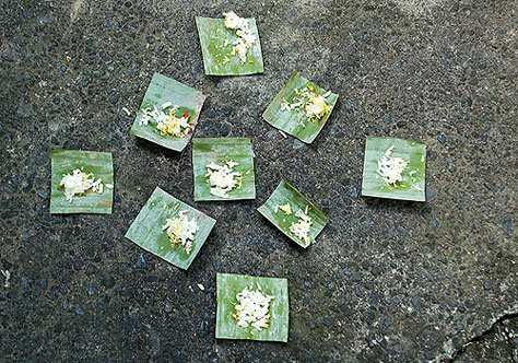 Rice offerings on banana leaves.