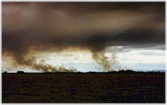 Burning fields, black sky.