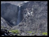 Loowit Falls with the western crater edge in the background as dust and old ash plume skyward.